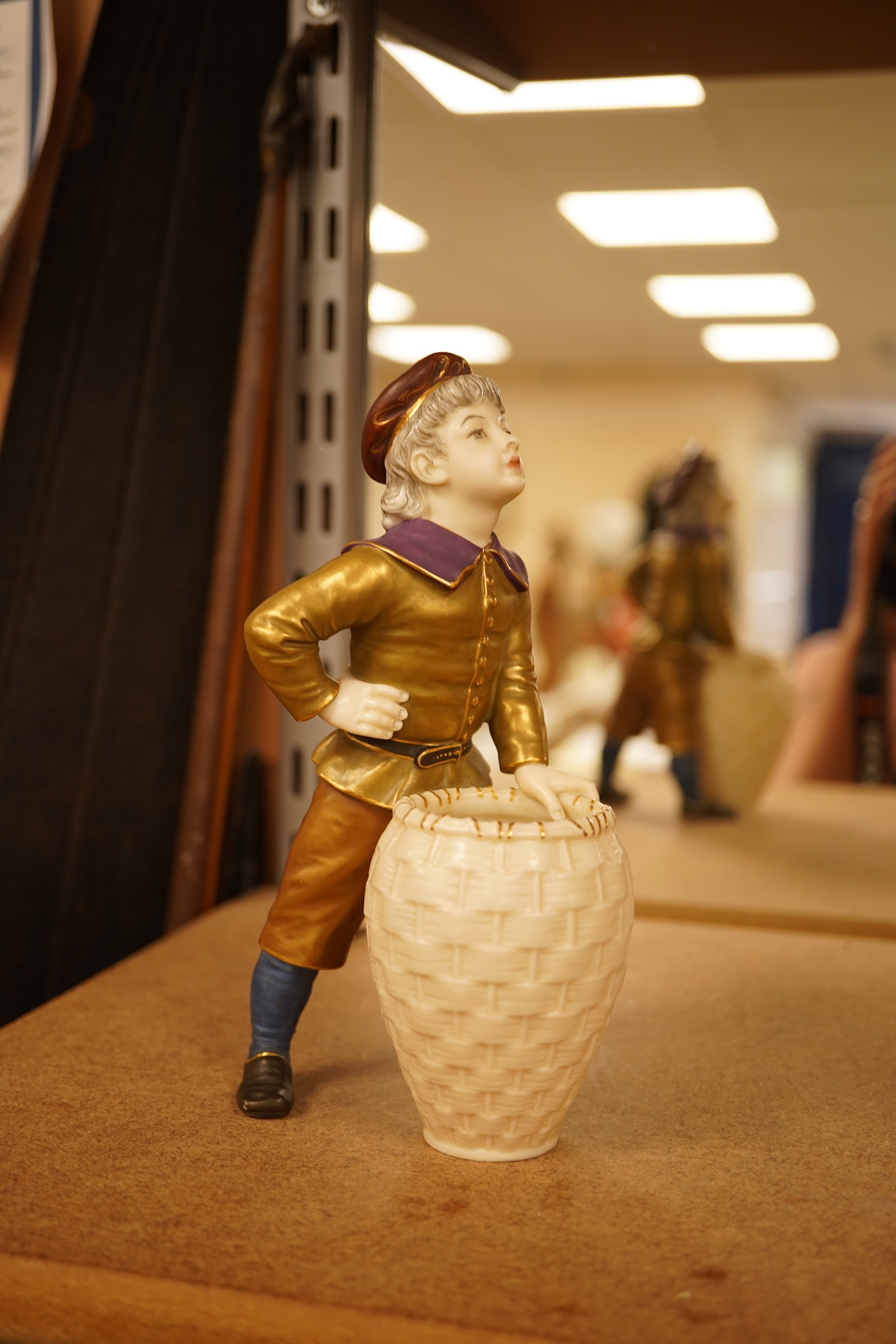 A late 19th century Royal Worcester figure of a boy with basket, 17.5cm high